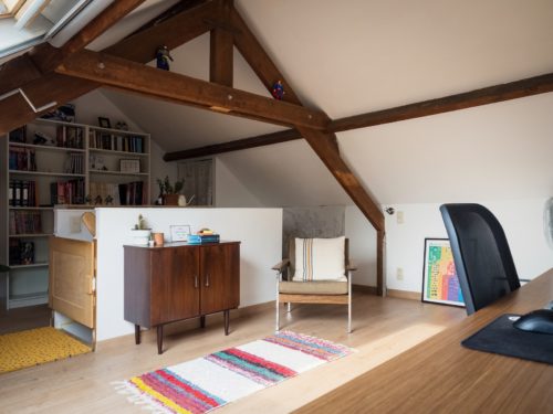 a living room with a chair and a book shelf